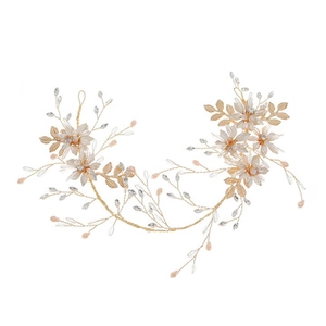 Détail de vigne à cheveux mariée en fil doré avec fleurs champagne et grappes de perles