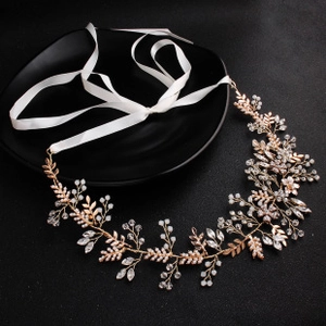 Close-up of handmade bridal headband with white pearls and rose gold leaf details