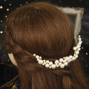 Detail eines handgefertigten Perlenhaarkamms in gewelltem Haar für elegante Hochzeiten