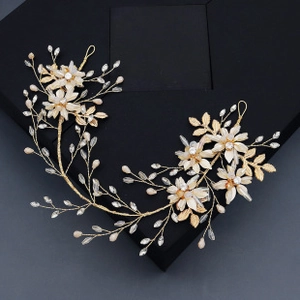 Close-up of handmade bridal headband with gold metal flowers and white fabric petals