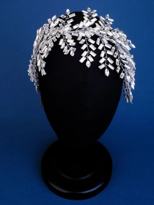 Macro detail of luxury bridal headband with clear crystal tassels and silver leaf design