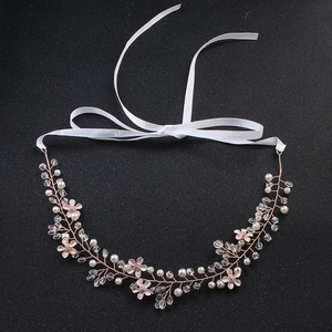 Détail macro d'un bandeau de mariée en or rose avec perles blanches et cristaux