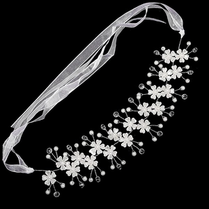 Détail de bandeau de mariée avec fleurs en tissu blanc, perles et rubans en mousseline