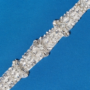 Detailed close-up of crystal bridal belt with marquise rhinestones on sheer white mesh