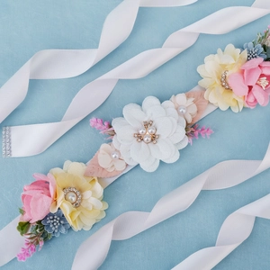 Detail of handmade bridal belt with pink fabric flowers, pearls and rhinestones decoration