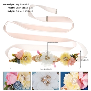 Macro detail of bridal belt with soft fabric flowers, imitation pearls and satin ribbon