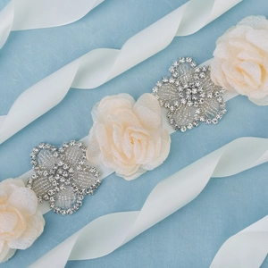 Detailed macro view of chiffon flowers and silver rhinestones on a satin ribbon sash