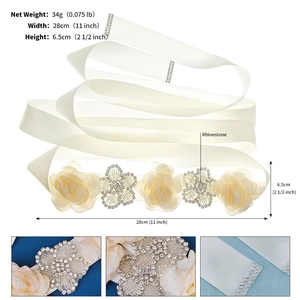 Detail of bridal sash with ivory silk flowers and heart-shaped rhinestone arrangement