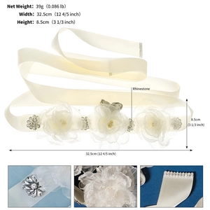 Detail view of bridal belt with white flowers and sparkling rhinestones on ivory satin ribbon