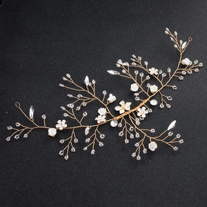 Detail der Braut-Haarranke mit goldener Draht, weißen Keramikblüten und Kristall-Strass