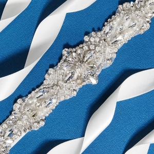 Macro détaillée de ceinture de mariée avec cristaux, perles et strass sur ruban blanc
