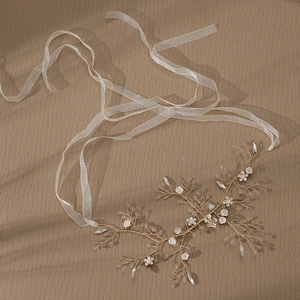 Detailed macro view of handmade bridal hairband with golden wire, white flowers and beads
