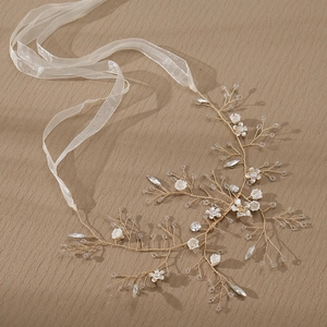 Handmade bridal hair band with gold wire flowers and crystal rhinestones on brown background