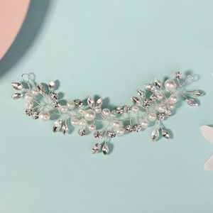 Detail of handmade bridal hair vine with white pearls and crystals on blue background
