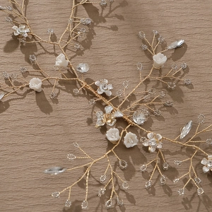 Elegant gold bridal headband with white ceramic flowers and sparkling crystals