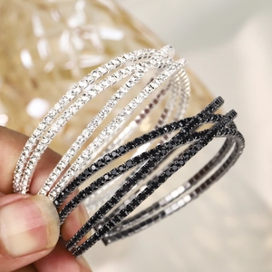 Détail macro de bracelets multicouches ornés de strass en finitions argent et noir