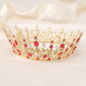 Détail d'une couronne de mariée dorée avec strass rouges et travail du métal raffiné