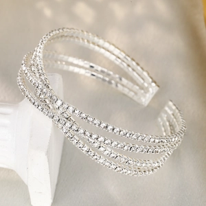 Détail d'un bracelet ouvert argenté multicouche avec quatre rangées de cristaux brillants