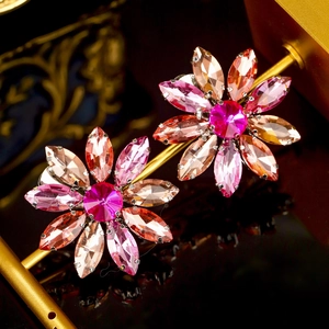 Detailopname van kristallen bloem haarspelden met roze stenen op een gouden basis