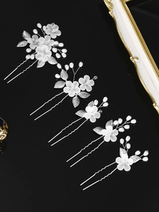 Detail view of 5-piece bridal hair pin set with white flowers, leaves and pearls