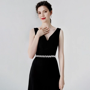 Close-up of crystal bridal belt detail on an elegant black V-neck sleeveless gown