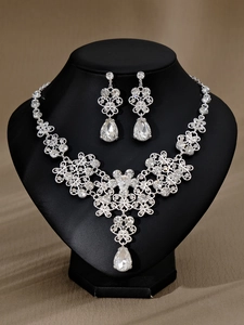 Silbernes Brautschmuck-Set mit Strass-Halskette und Tropfenohrringen auf einer schwarzen Büste