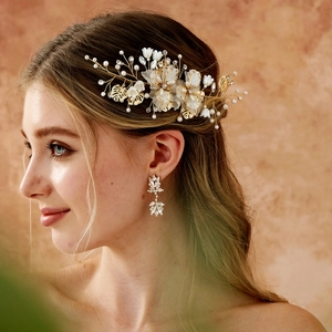 Close-up of bridal hair comb and earrings set with ceramic flowers and pearls
