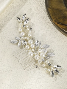 Detail of silver bridal hair comb with elegant faux pearls and sparkling rhinestones