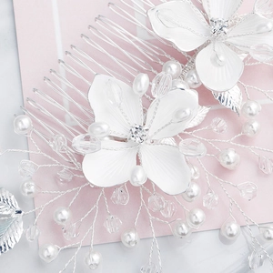 Detail of handcrafted bridal hair comb with silver alloy flowers and white pearls