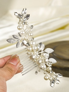 Detail of handmade bridal hair comb with silver leaves, white pearls and clear crystals