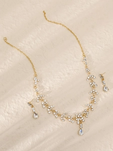 Nahaufnahme von goldenem Brautschmuckset mit Glanz-Strass und birnenförmigen Anhängern