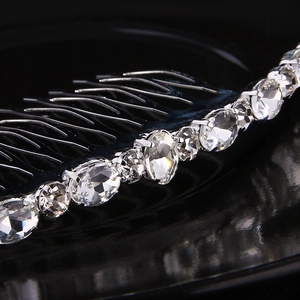 Macro detail of silver hair comb with oval-cut rhinestones in secure four-prong setting