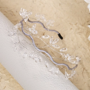 Detail of handmade crystal bead headband with silver wire vines on grey satin base