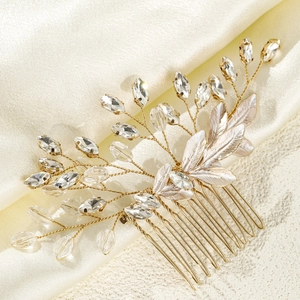 Detail eines handgefertigten Brauthaarkamms mit Kristallen und goldenen Metallblättern