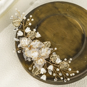 Exquisite bridal floral hair clip with pearl petals, gold leaves, and crystals