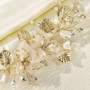 Elegant bridal headpiece with gold leaves, white shell flowers and pearls on satin