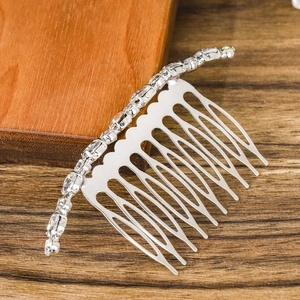 Silver bridal hair comb with sparkling rhinestones on a warm wooden background