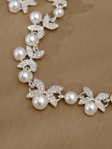 Nahaufnahme von elegantem Brautschmuckset mit Glanzperlen und Strass-Schmetterlingen