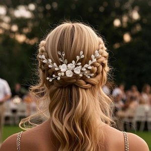 Detail of white clay flower hair comb with pearls styled in a bridal updo hairstyle