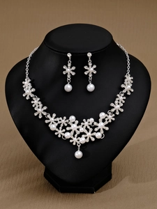 Detail des Brautschmuck-Sets mit Perlen und Strasssteinen auf floraler Halskette
