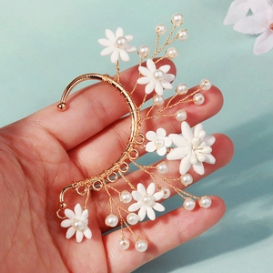 Detail of handmade gold wire ear cuff with white 3D clay flowers and elegant pearls