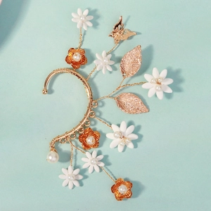Close-up of handmade floral ear cuff with gold butterfly, white flowers and pearls