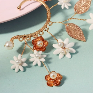 Detail of handcrafted gold floral ear cuff with white beads and pearls for brides