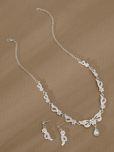 Makroaufnahme von Brautschmuck-Set mit Kristall-Schmetterlingsflügeln und Tropfenanhänger