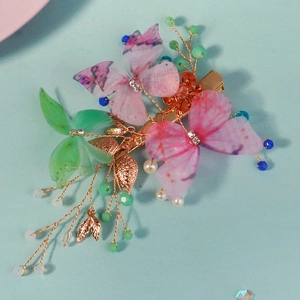 Barrette papillon style féerique avec perles de cristal colorées sur fond bleu clair