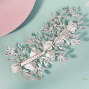 Detail of handmade bridal hair clip with white flowers and silver metal leaves
