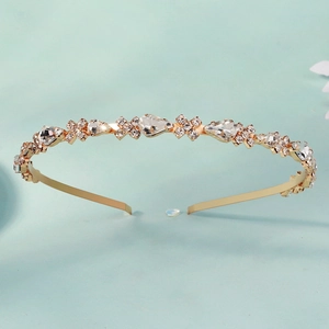 Detail of a gold headband with clear water-drop rhinestones and flower crystals