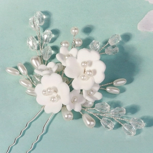 Detail of handmade bridal hair pins with white fabric flowers and pearl accents