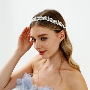 Gros plan sur un bandeau de mariée fait main avec perles blanches et fleurs en strass