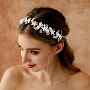 Close-up of golden leaf headband with white flowers, pearls and crystal beads on a model